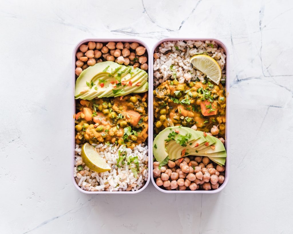 rice, vegetarian curry, chickpeas, lemon and avocado prepped in tubs