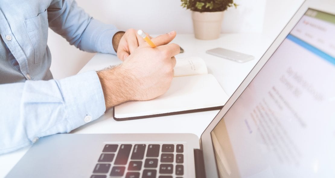 Man working from computer and notebook